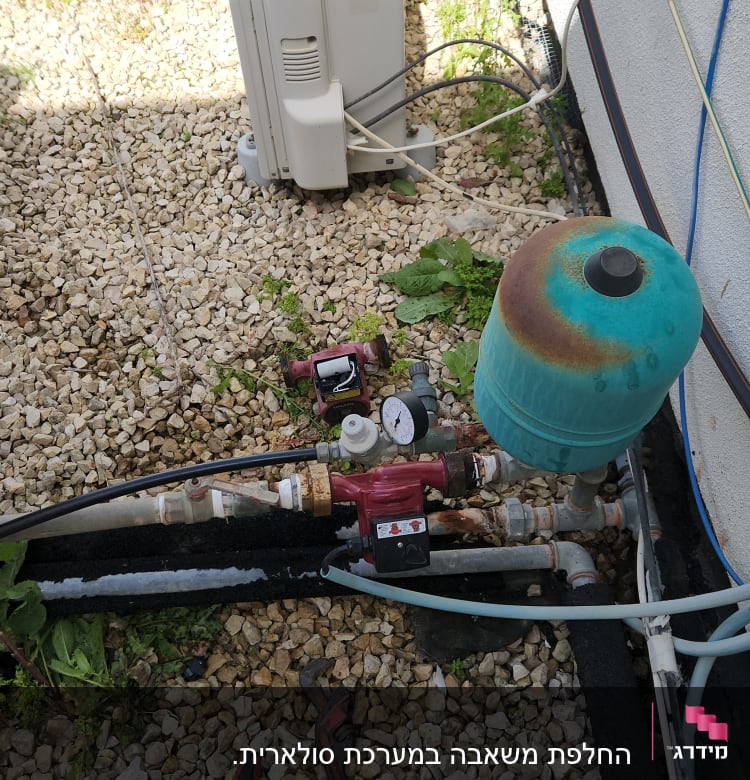 מערכת דודים עם מד לחץ וכלים על הקרקע